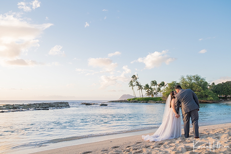 bride and groom kissing with hawaiian sunset in the background 
