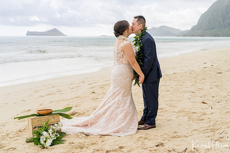 just married husband and wife kiss on oahu beach 