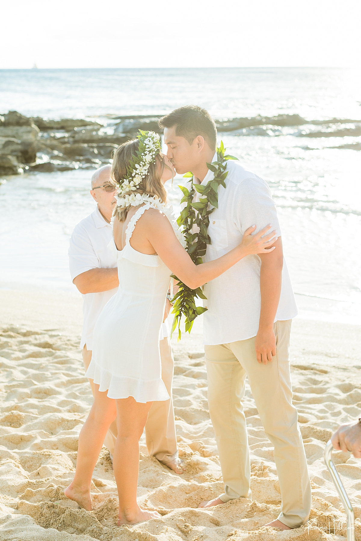 couple share a first kiss during wedding on oahu beach 
