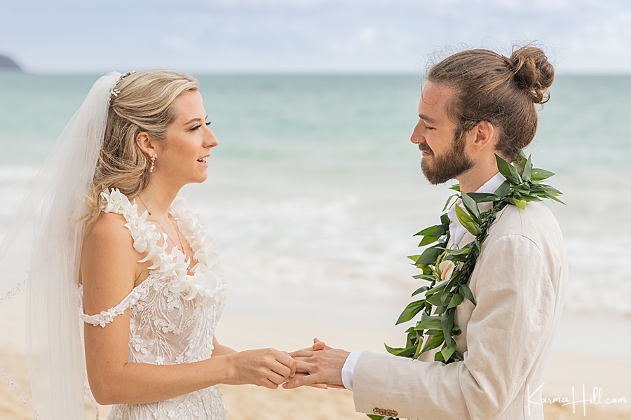 bride gives groom ring at beach wedidng