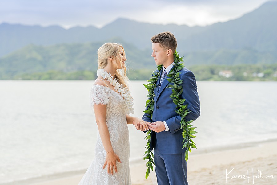 groom giving bride ring at hawaii ceremony