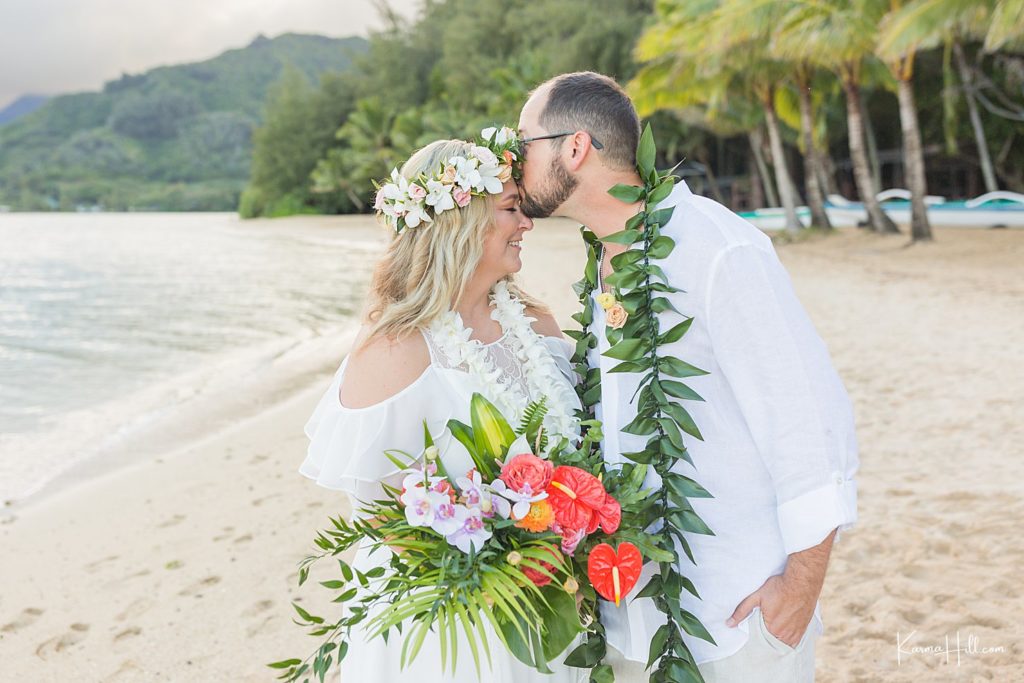 newlyweds on beach in oahu